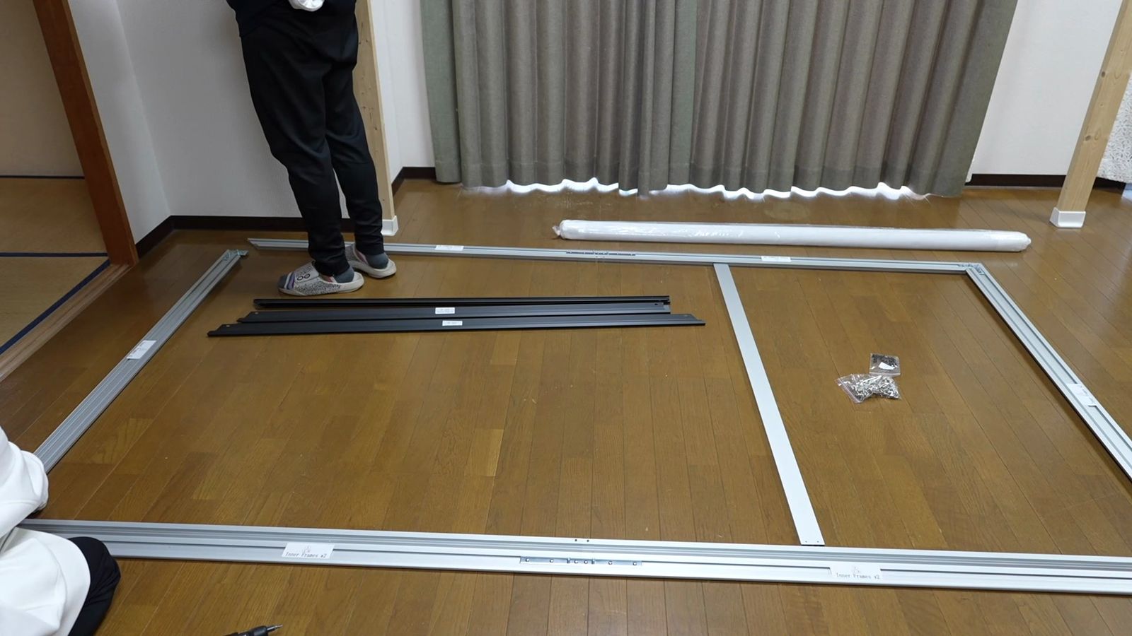 床に広げて組み立てている固定フレーム