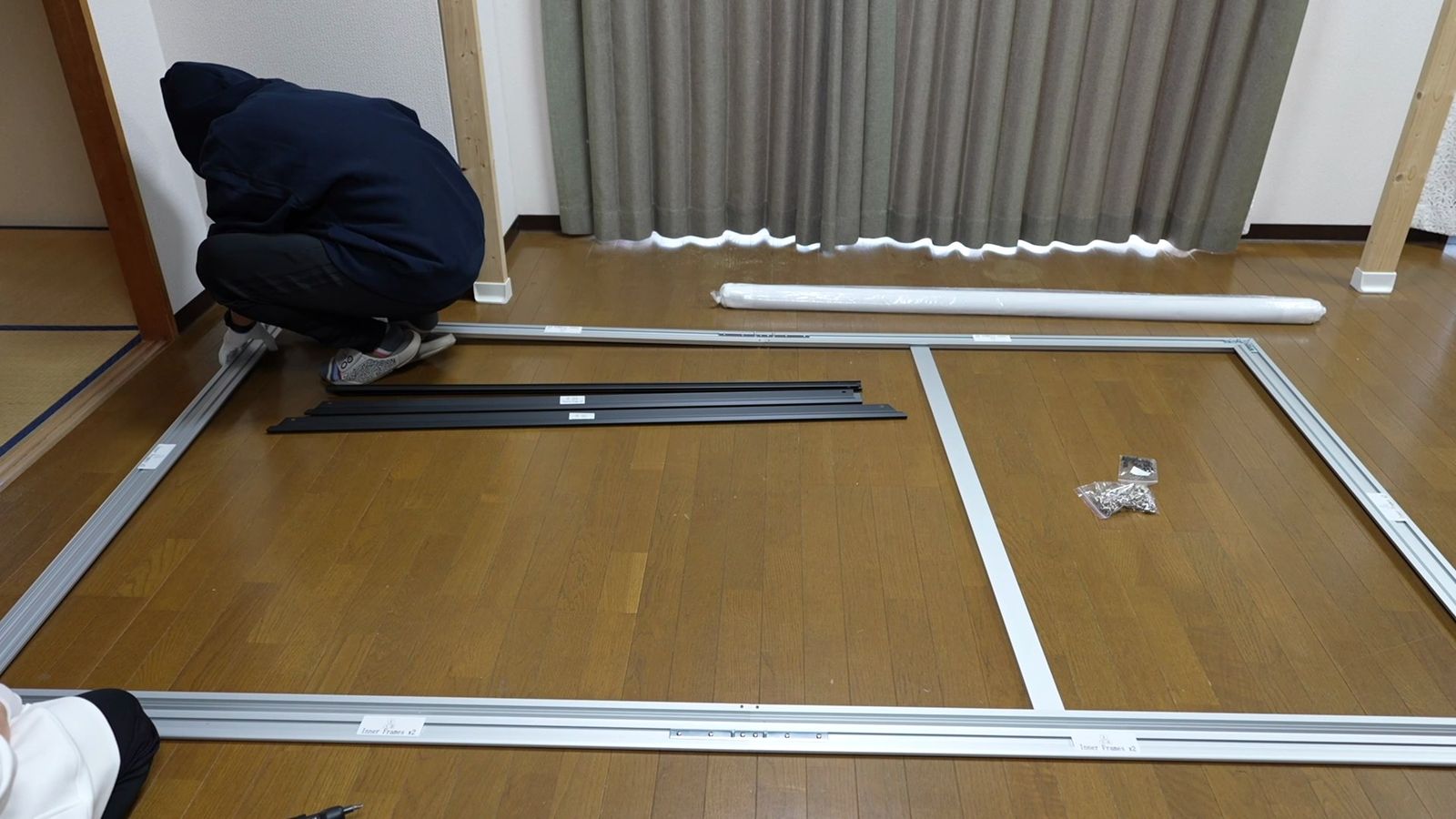2人がかりでフレームに生地を張っているところ