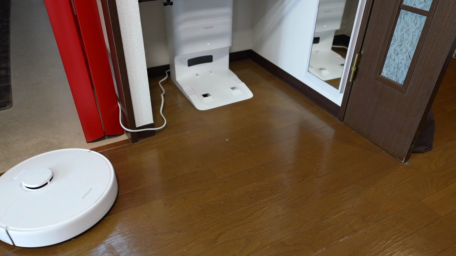 壁際に置いたゴミ収集ドックと、床にあるロボット掃除機本体