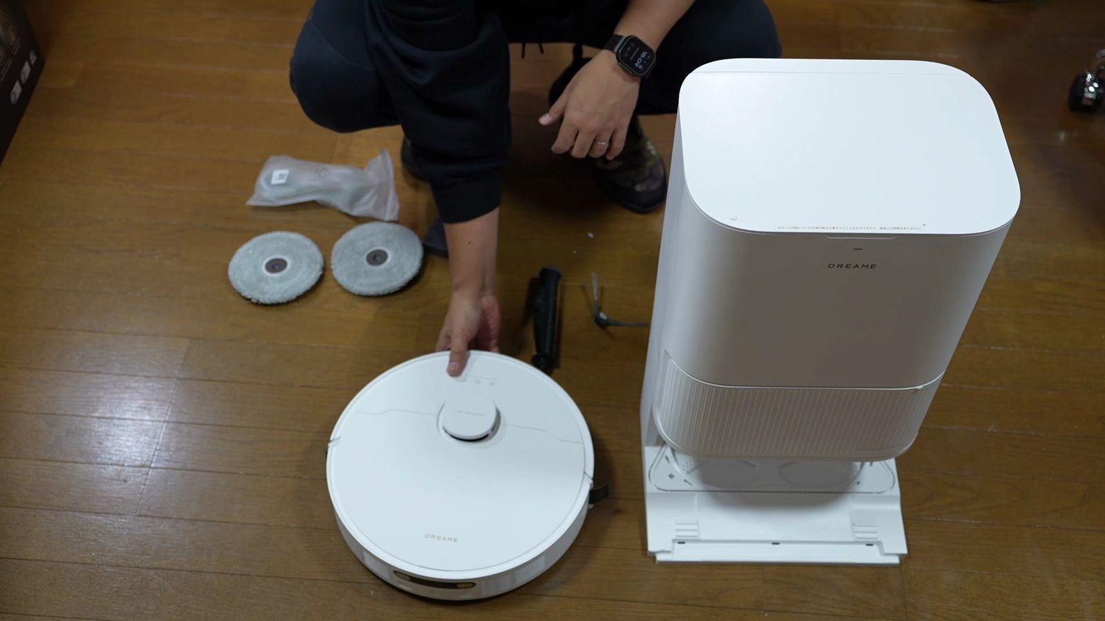 ロボット掃除機本体と背の高いゴミ収集ドックを並べたカット