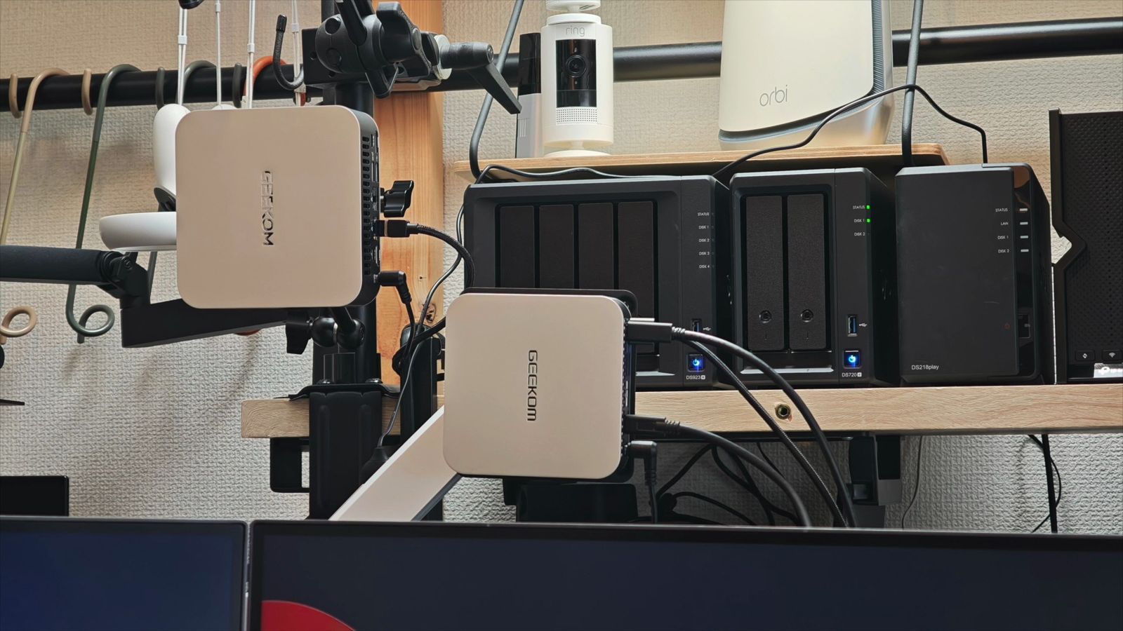 棚に並んだSynology・UGREENのNASと、モニターアームに固定したGEEKOM A9 MAXのLAN配線