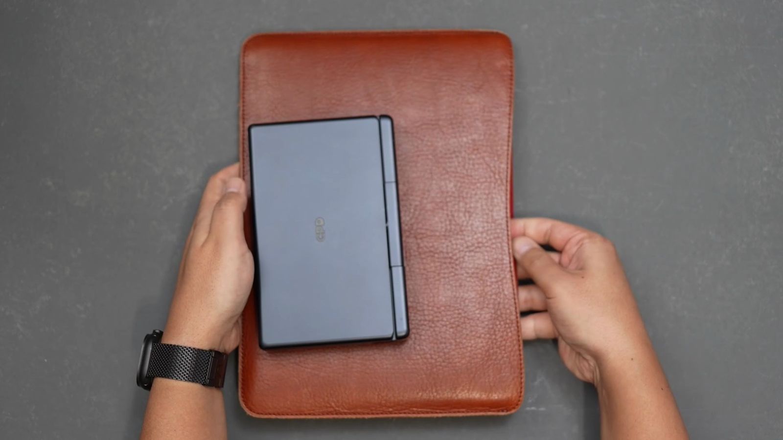 レザースリーブの上に置いたGPD MicroPC 2を真上から。サイズ差が一目で分かる