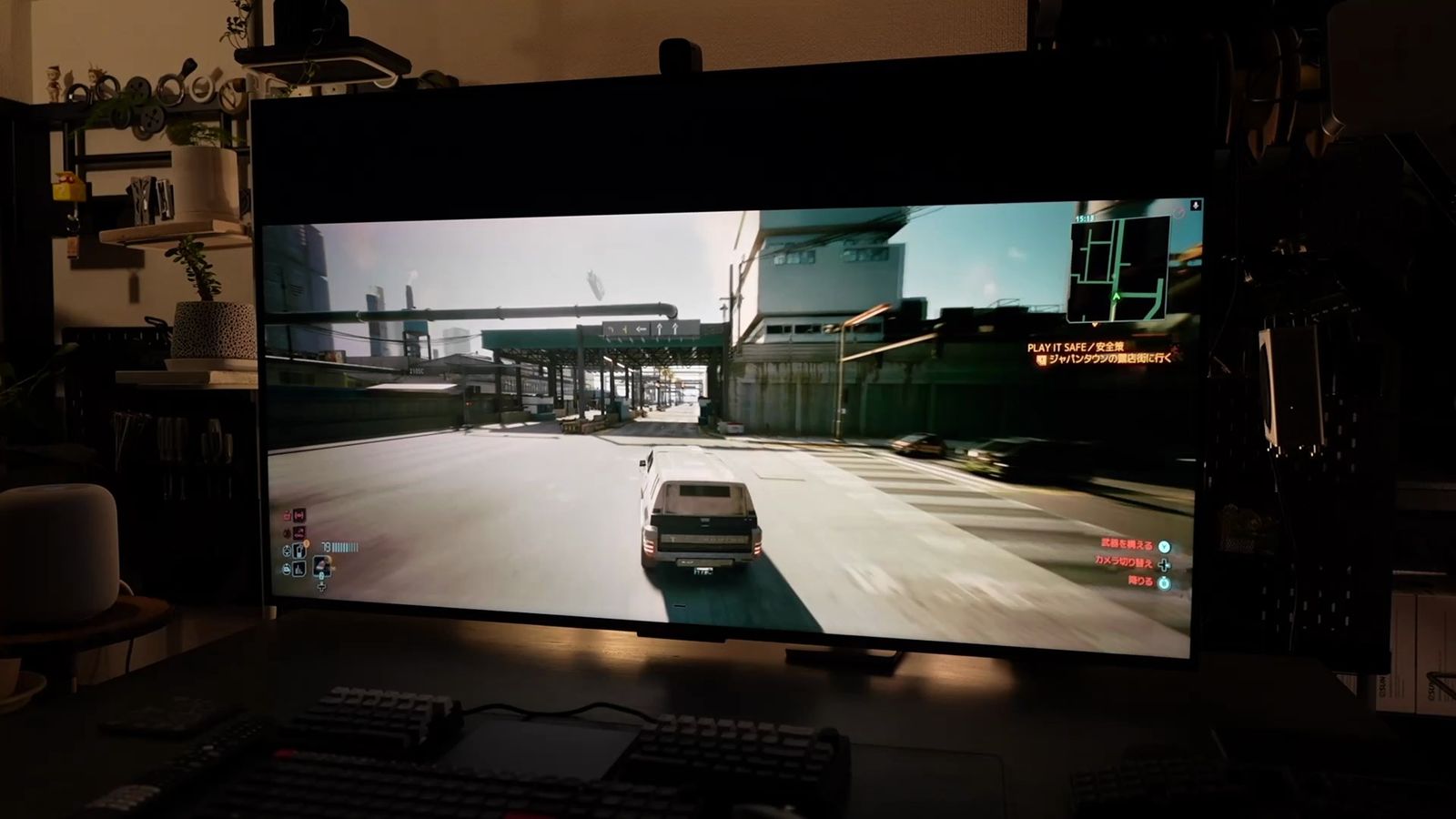 55型テレビにウルトラワイド(上下に黒帯が入る横長)表示したゲーム画面。市街地の道路を車で走行している場面