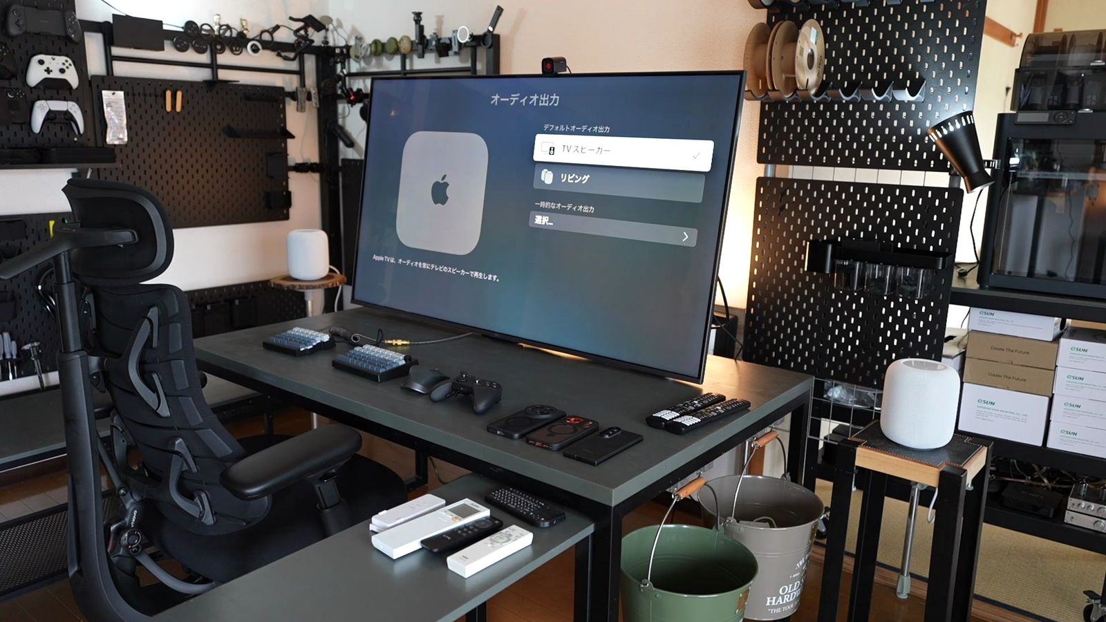 テレビの音声出力設定画面。デスクにはPCやゲーム機など複数の機器が並ぶ