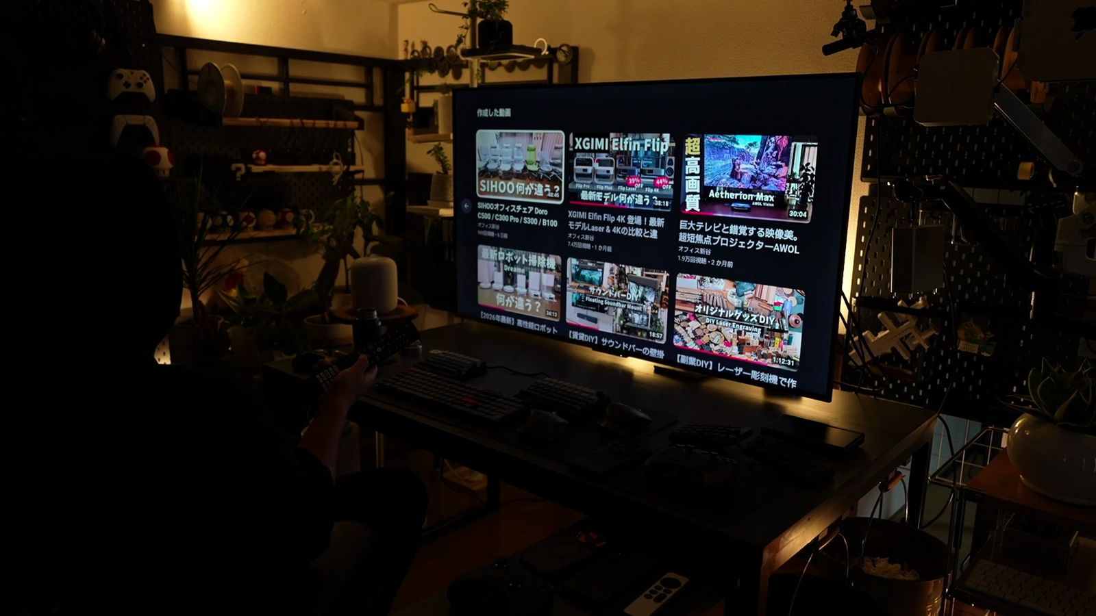 55型テレビにテレビ番組の一覧画面を表示したデスク。サムネイル付きの番組リストが画面に並ぶ