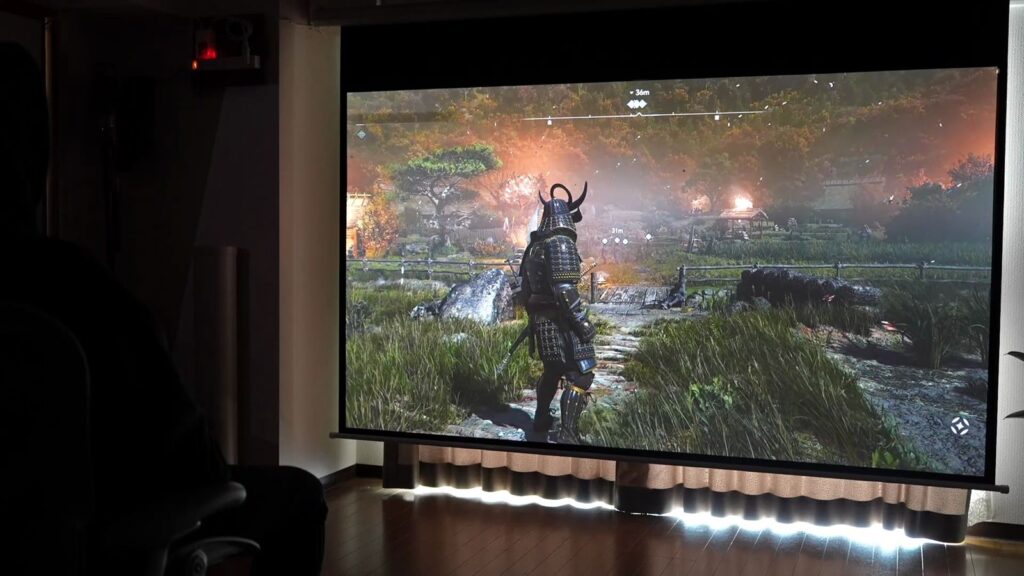 暗くした部屋でスクリーンいっぱいに映したゲーム映像