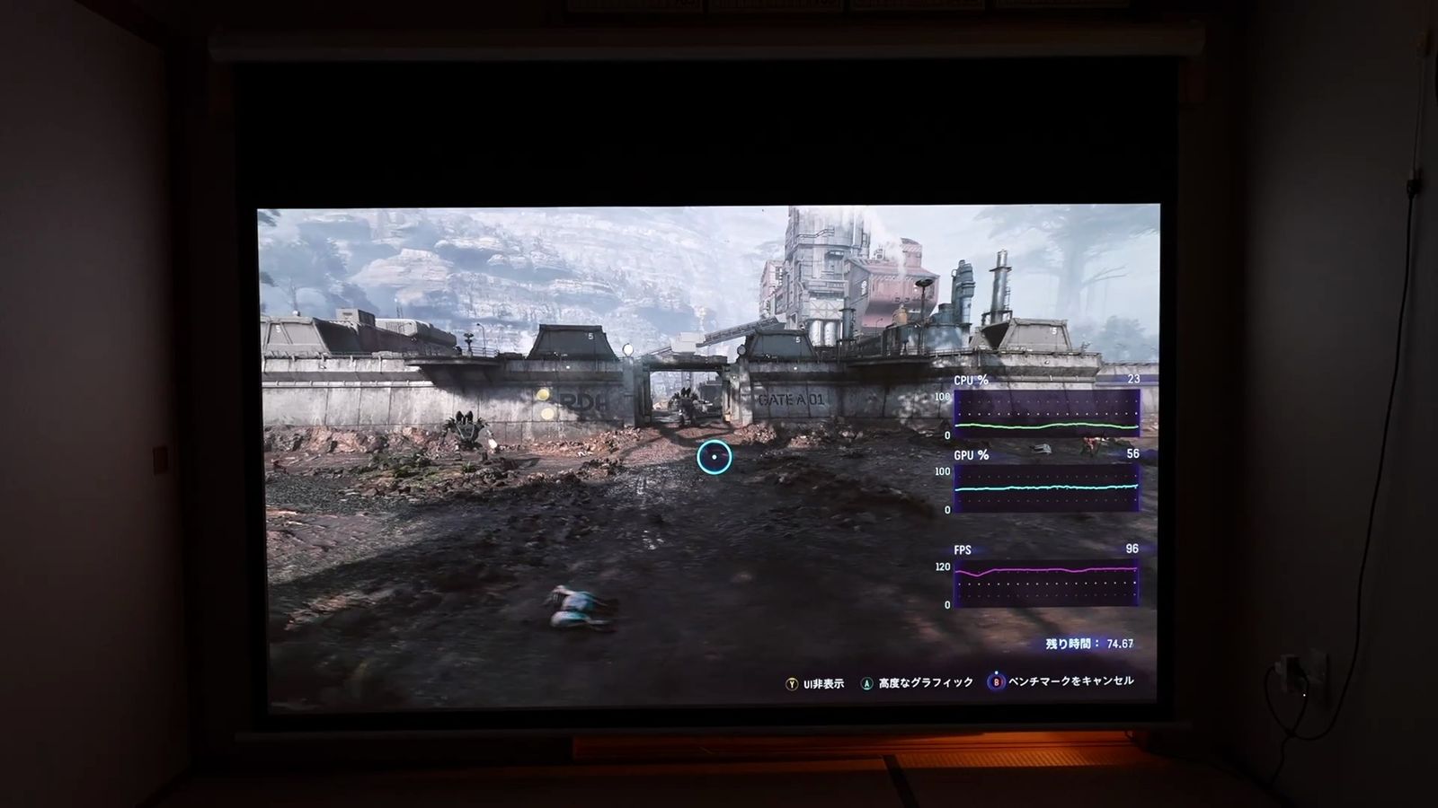 暗い部屋のスクリーンに投影されたゲームのベンチマーク映像