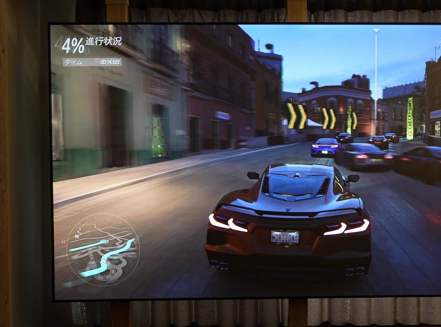 明るい部屋でALRスクリーンに投影したレースゲーム画面。青空も白飛びせず色が濃い
