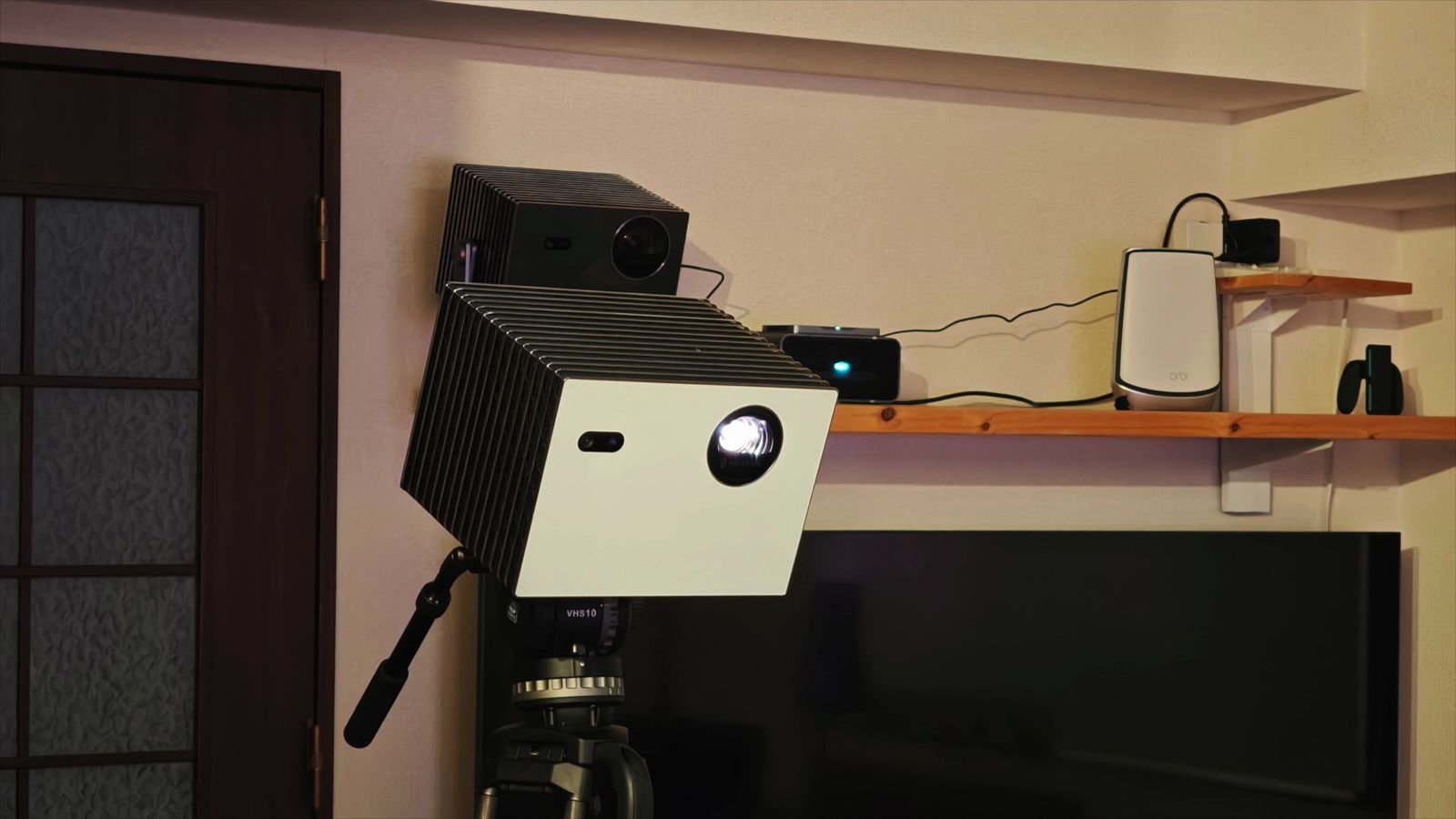 カメラ用ビデオ三脚に載せたStreamMaster Plus2。奥の棚にも黒い本体が1台