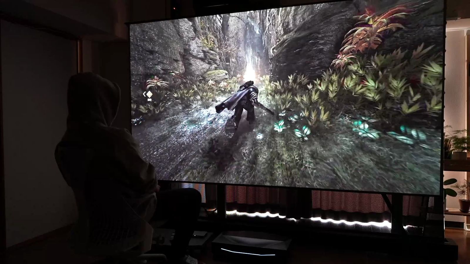 森の中を進むゲームの画面を大画面に投影したところ