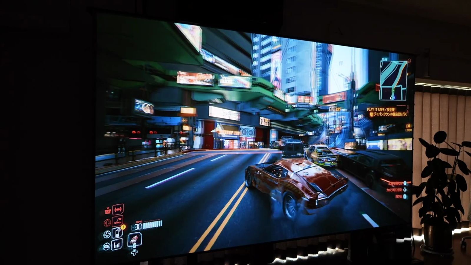 夜の街を走るレースゲームを大画面に投影したところ