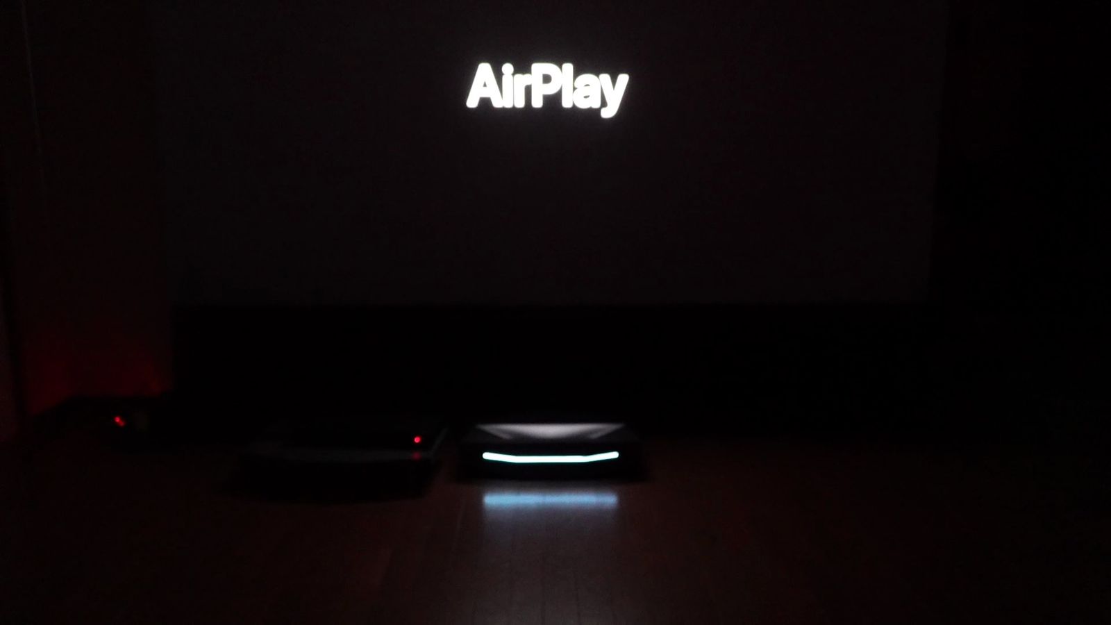 暗い部屋で投影画面に表示したAirPlayの文字