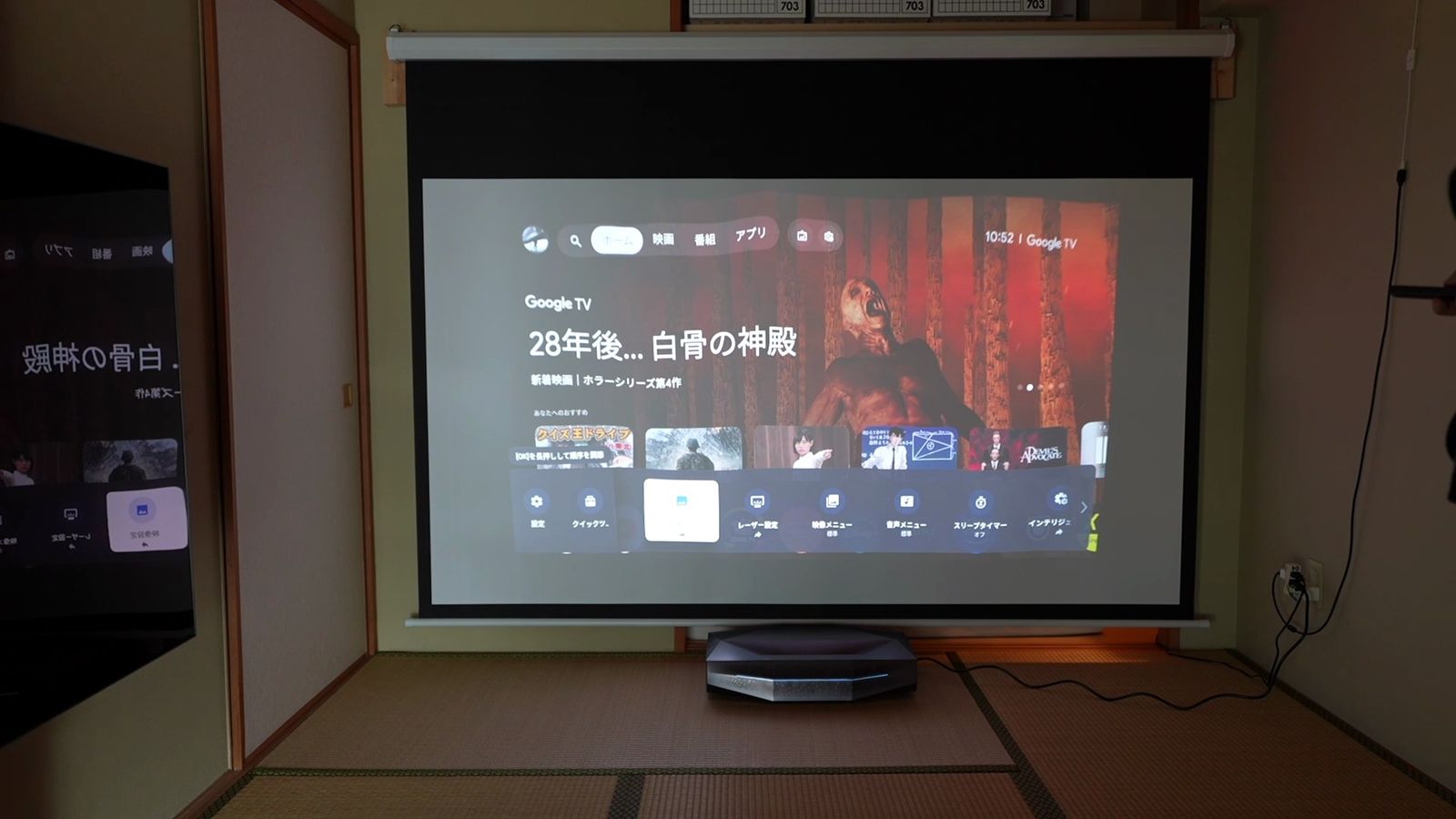 和室の吊り下げタイプのスクリーンに、手前に置いた本体から投影しているところ