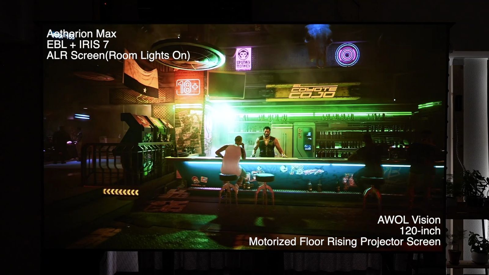 照明をつけた部屋で、AWOL Visionの120インチ床置き電動ALRスクリーンに投影したバーのシーン