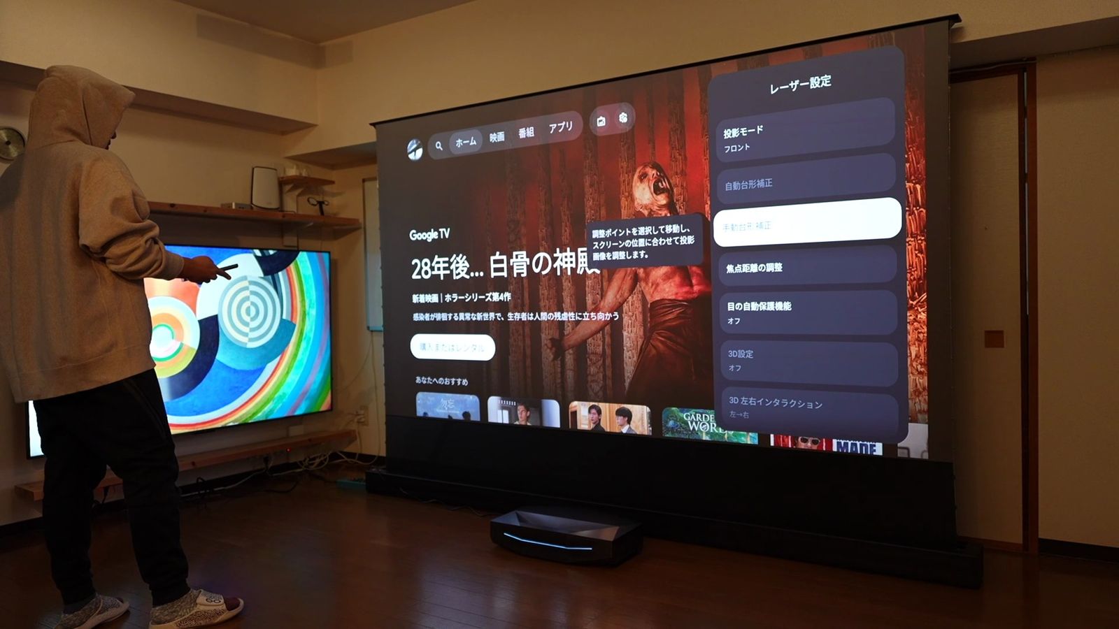 投影中のスクリーンのすぐ横に立っているところ