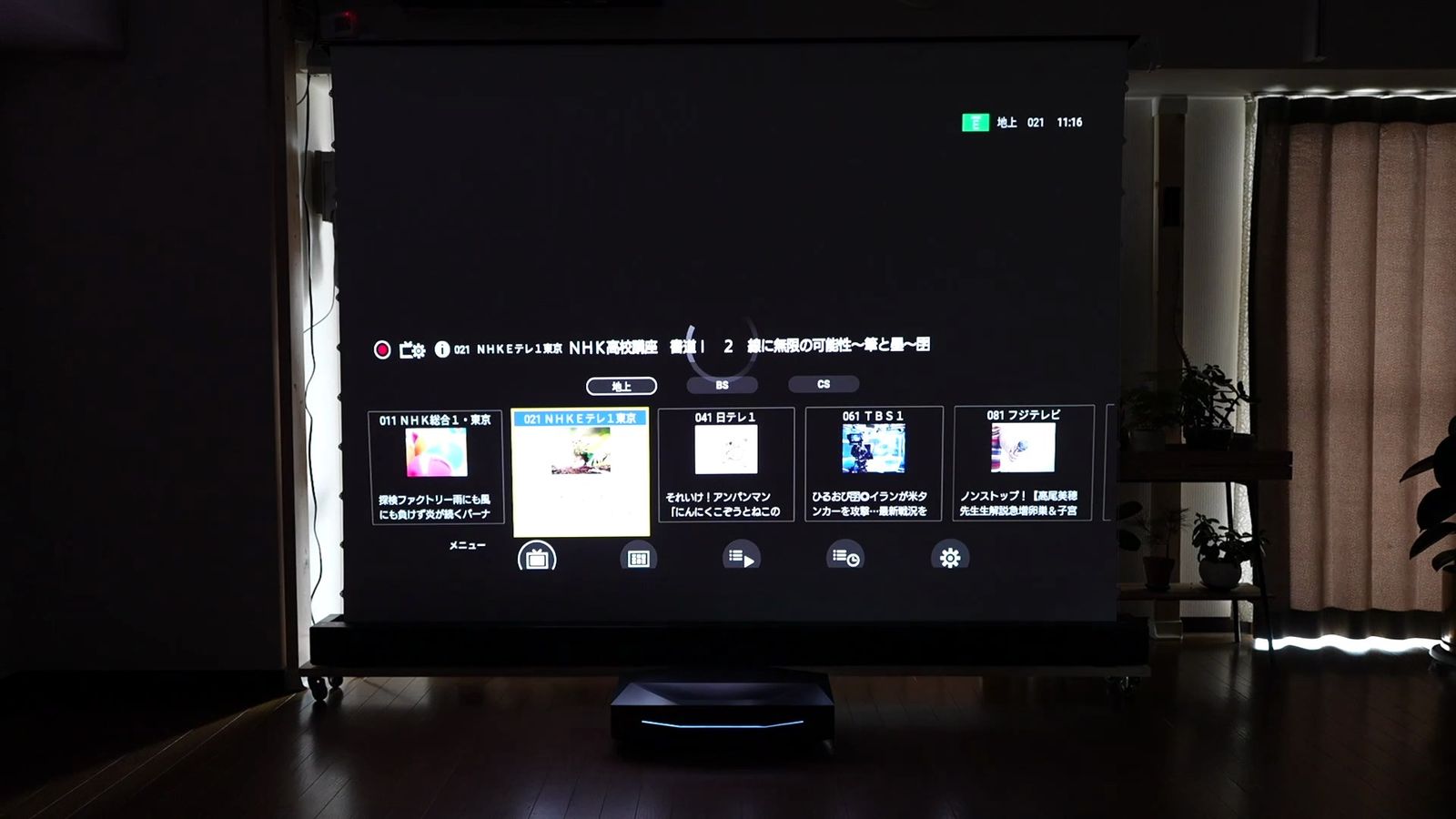 暗い部屋で投影したテレビ番組の視聴アプリの画面
