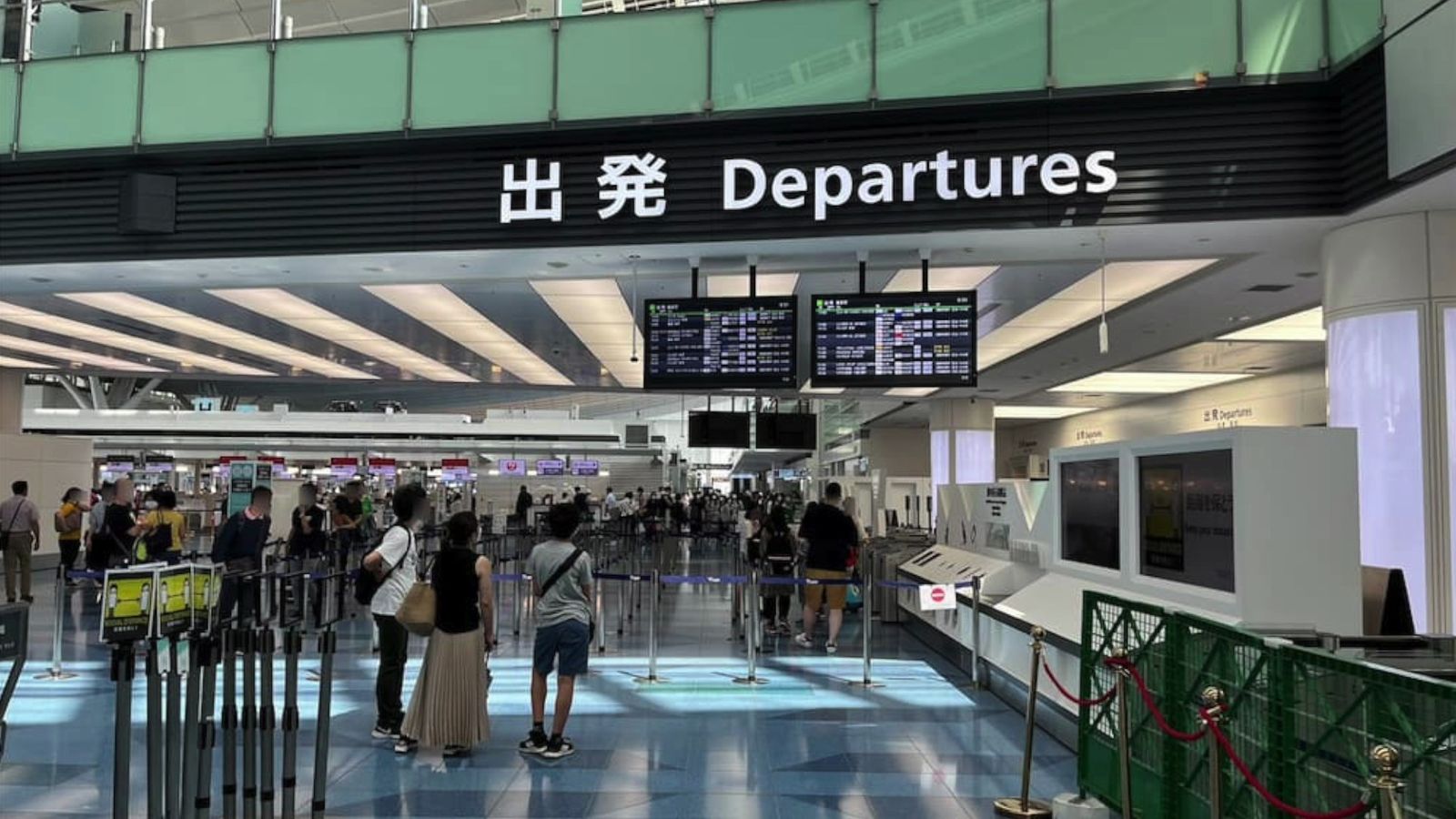 空港の出発ロビー。「出発 Departures」の看板