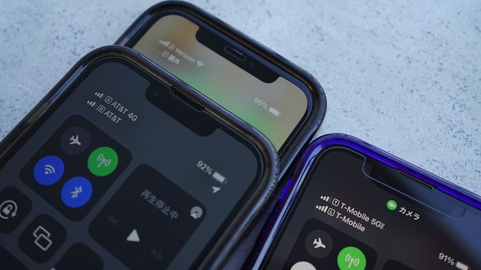 並べたiPhoneのアンテナ表示。手前はAT&T、奥はVerizon、右はT-Mobile