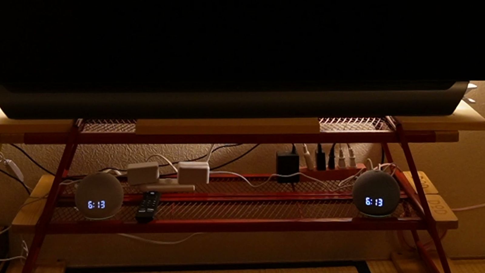 暗い部屋のテレビ台で、時刻を表示している2台のEcho Dot with clock