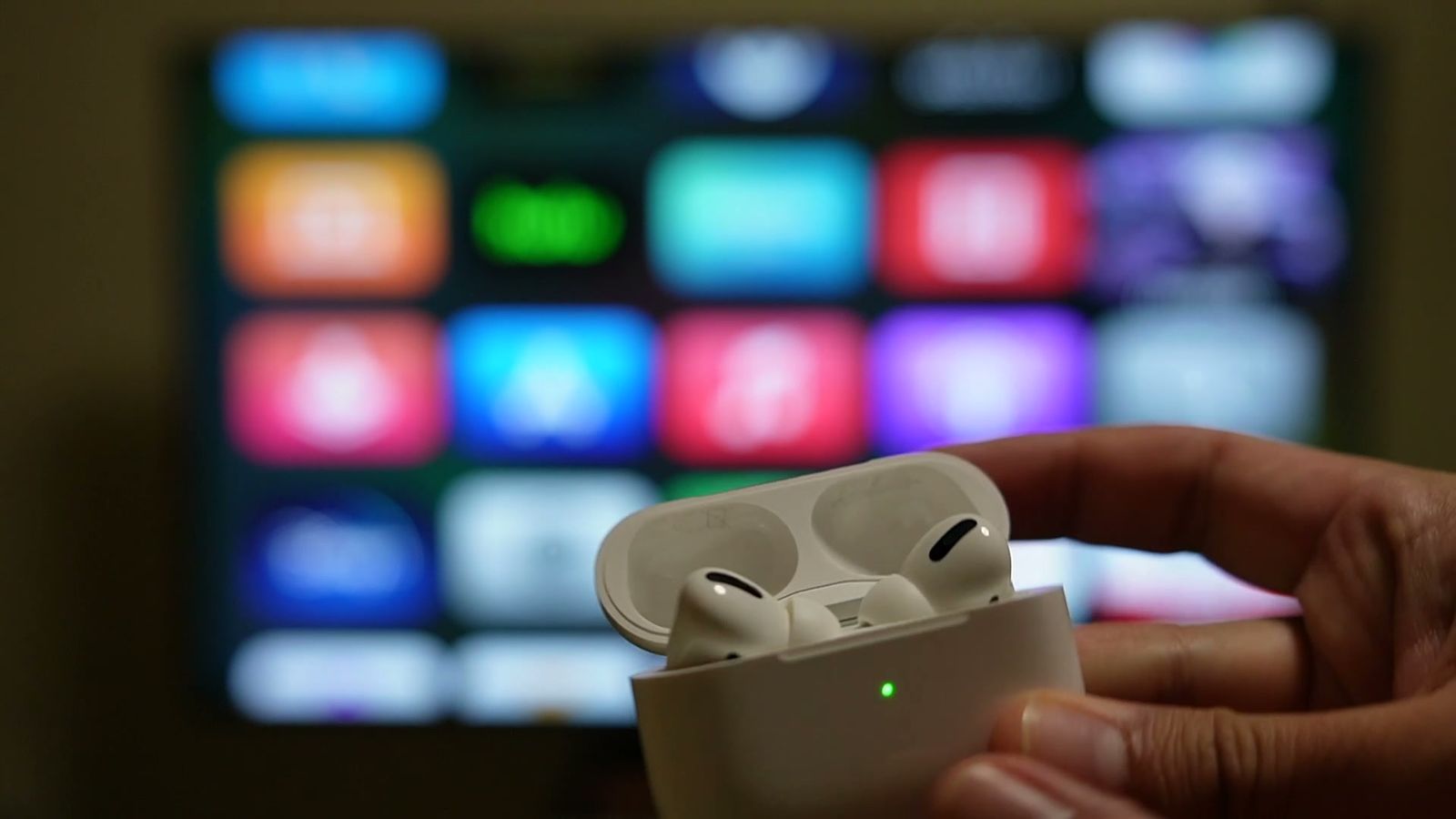 テレビの前でAirPods Proのケースを開けているところ