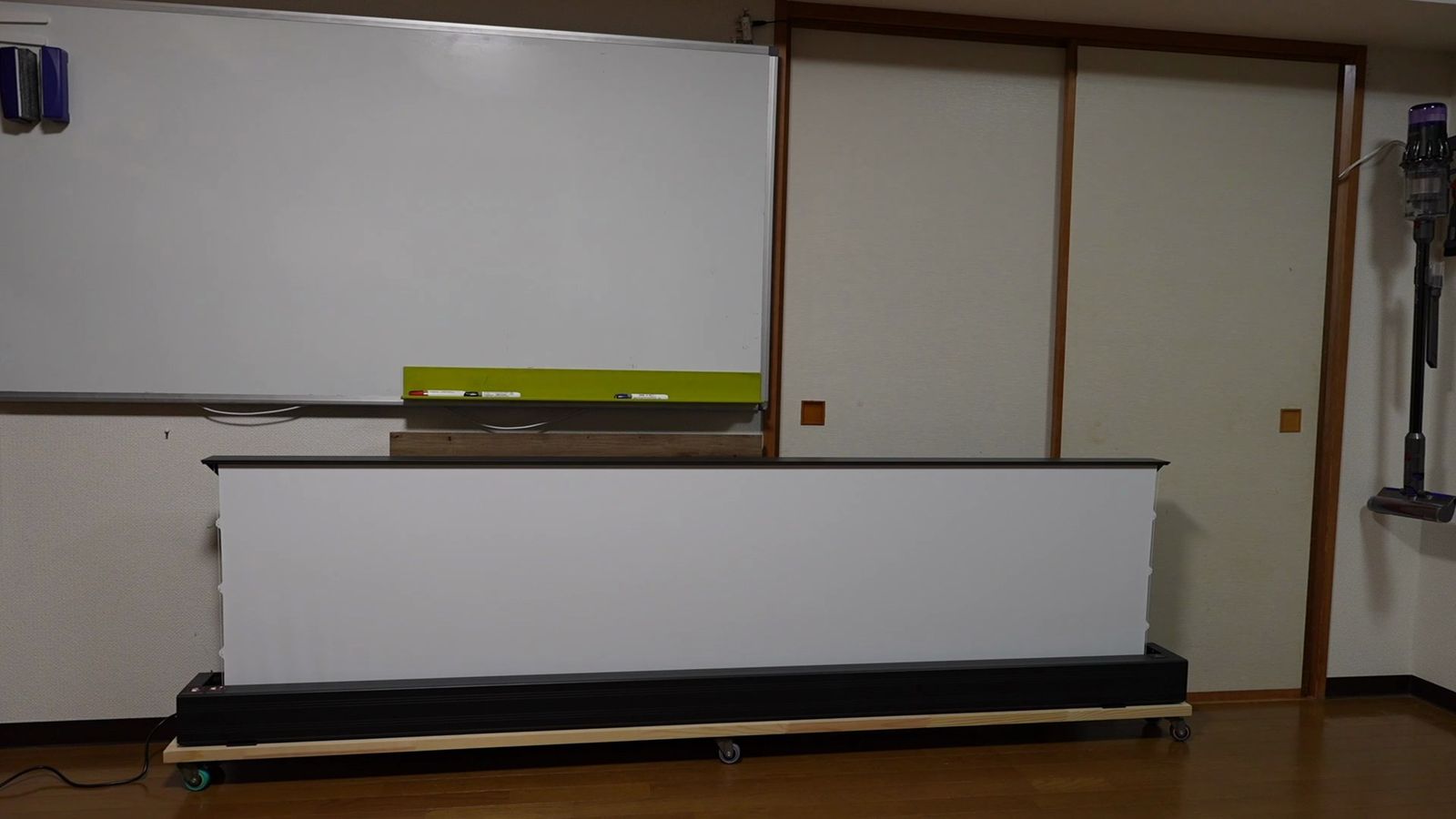 ふすまのある部屋の床に置いて上げた自立式スクリーン