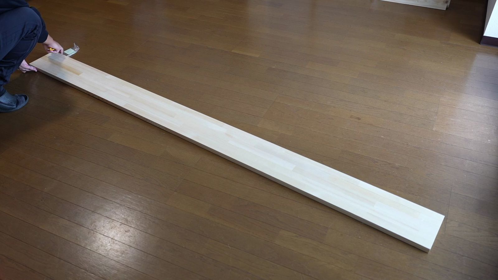床に置いた長い赤松の集成材の板
