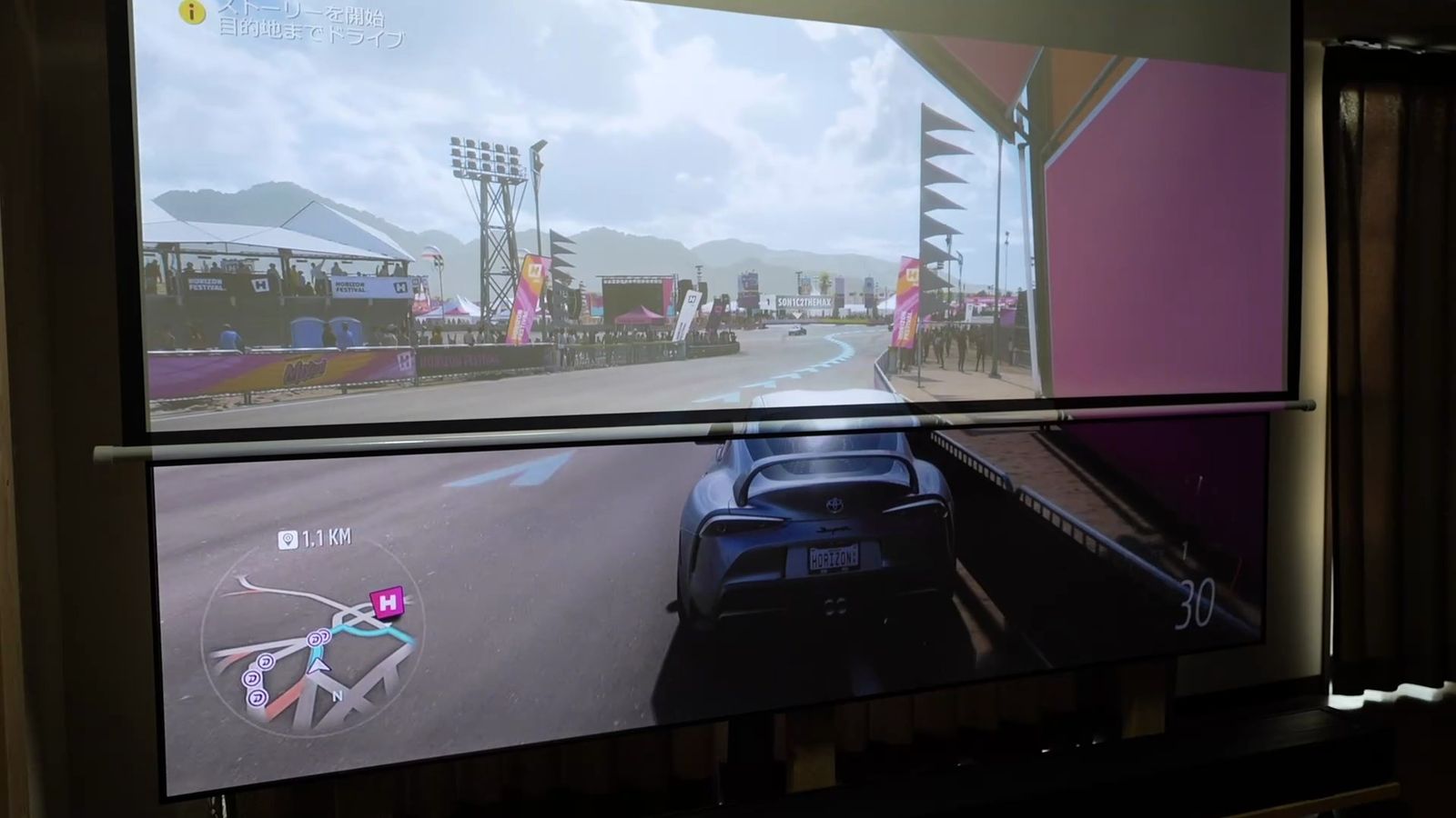 照明をつけた部屋で、上下に並べたスクリーンに同じレースゲームを投影したところ。上側は白く霞んでいる