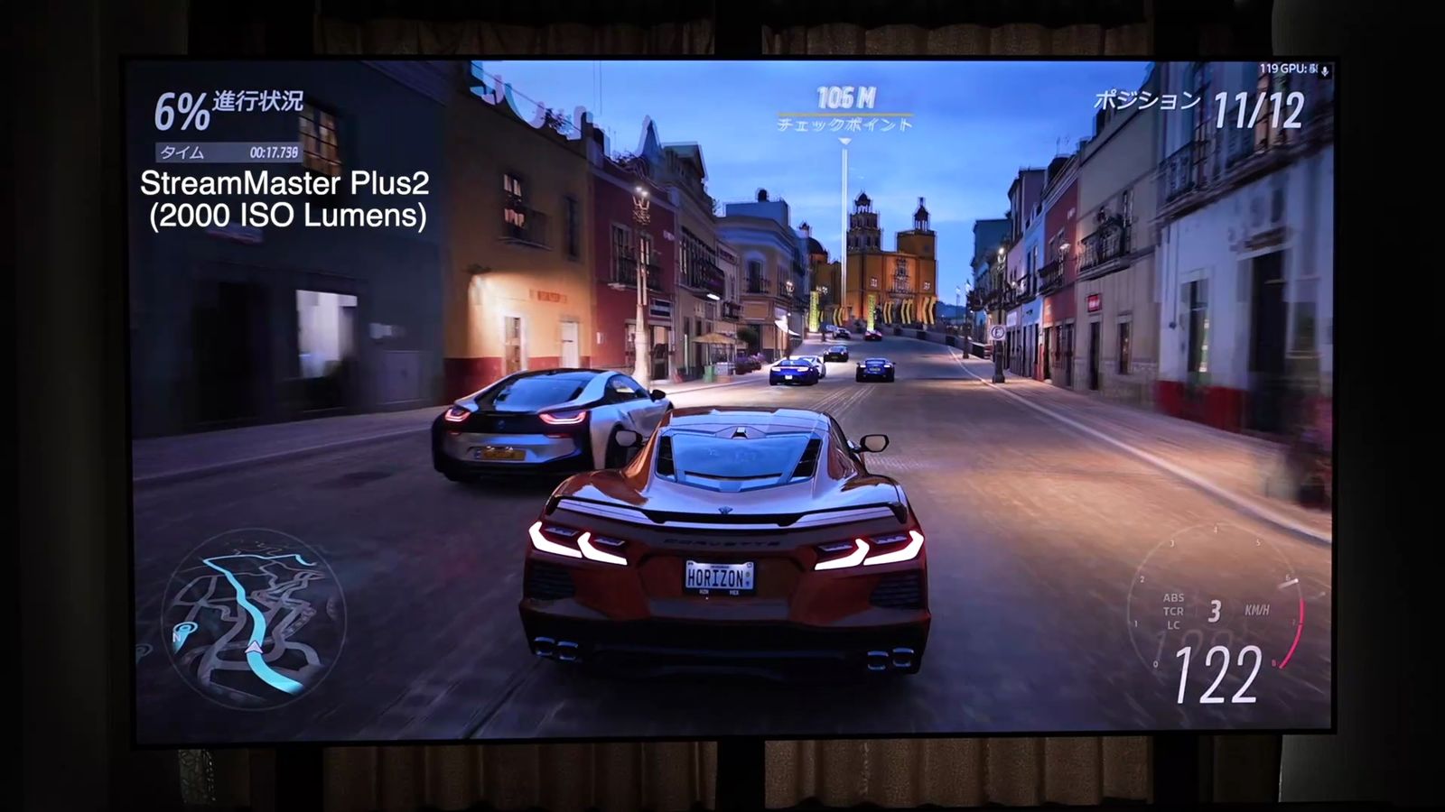 StreamMaster Plus2（2000 ISO Lumens）の文字が入った、ALRスクリーンへのレースゲームの投影映像