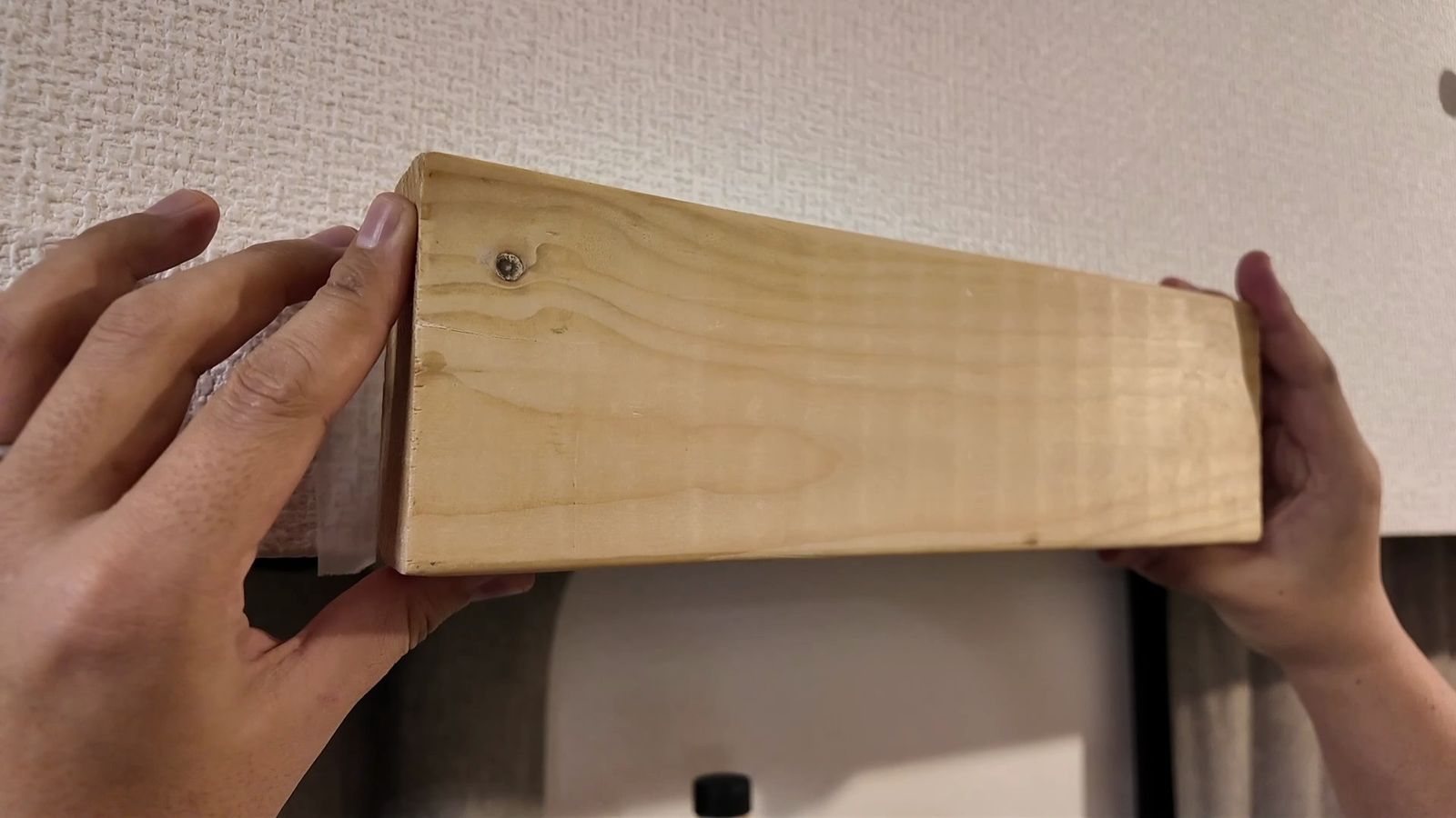 ホルダーに2×4材を押し当てて仮固定する様子