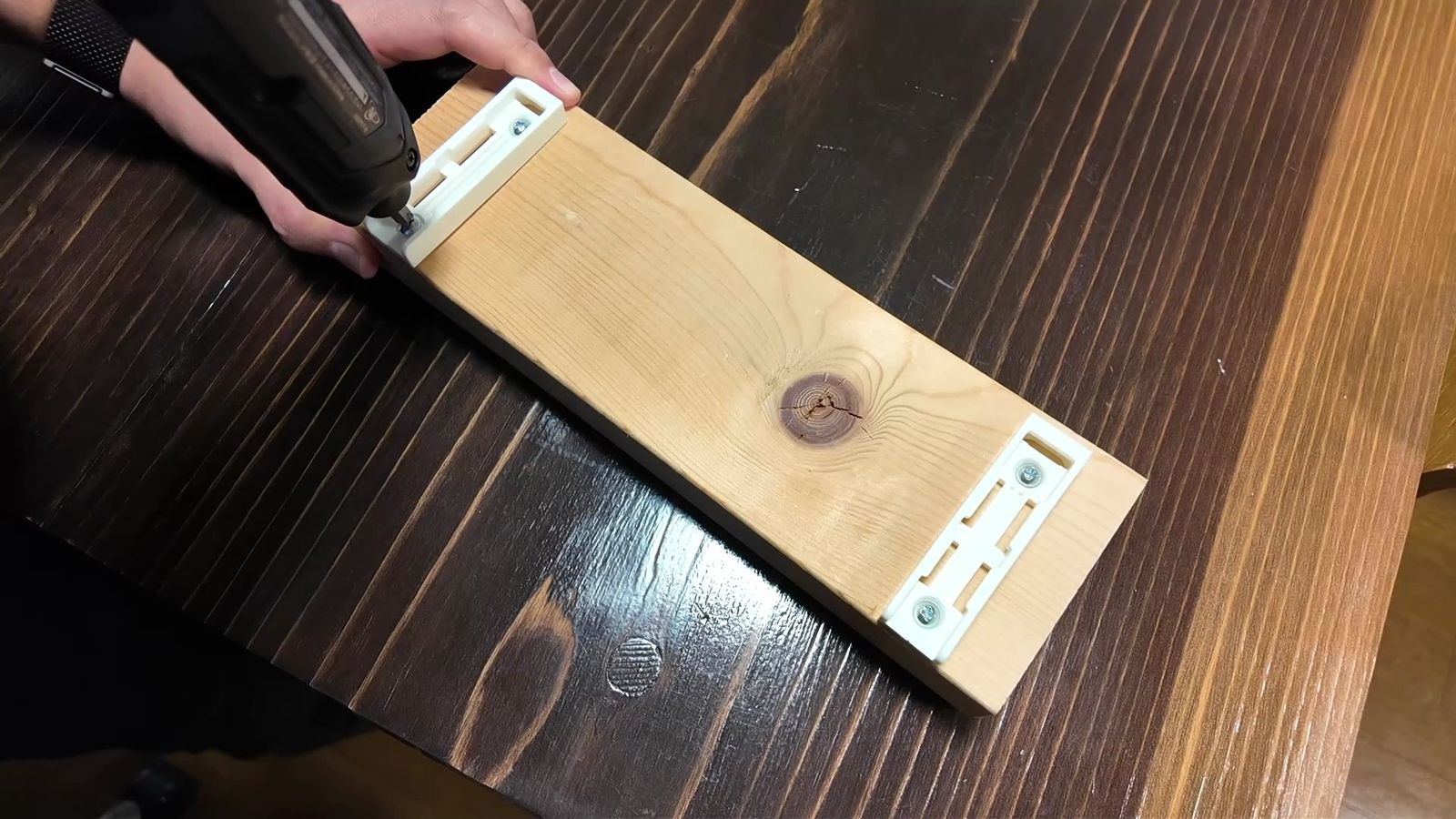 ホルダーを板にネジで固定する様子