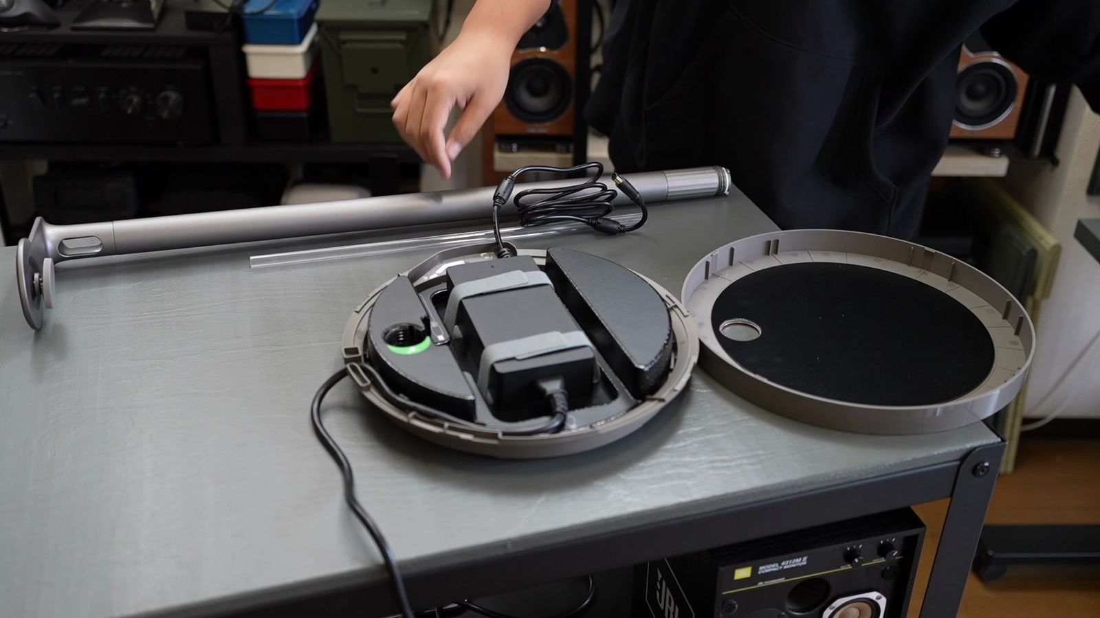 フロアスタンドUltraの台座に電源アダプターを収納する様子