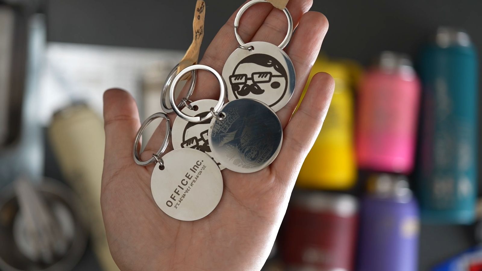 手に載せた彫刻済みの金属のキーホルダー
