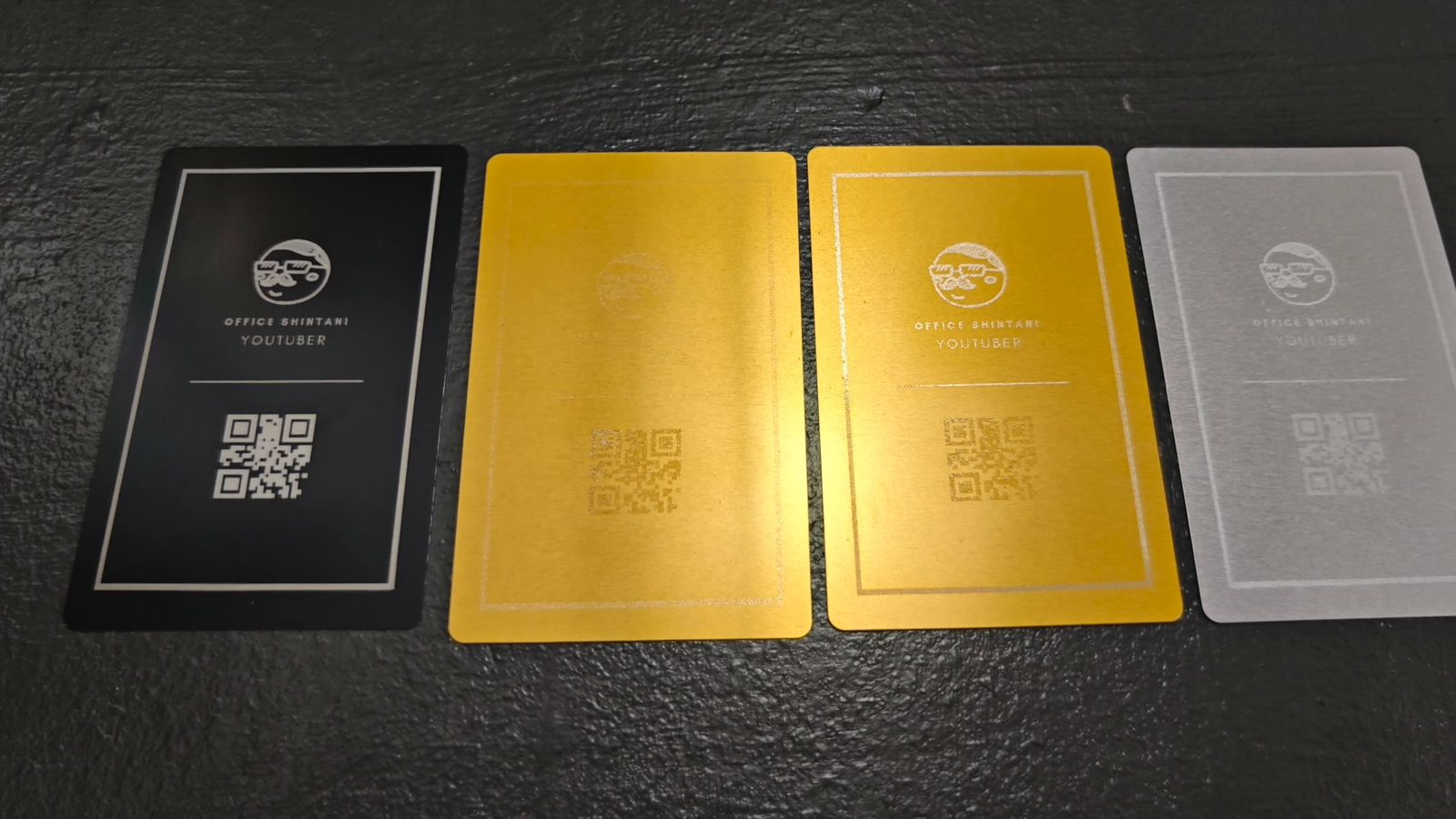 ロゴとQRコードを彫刻した黒、金、銀のカード