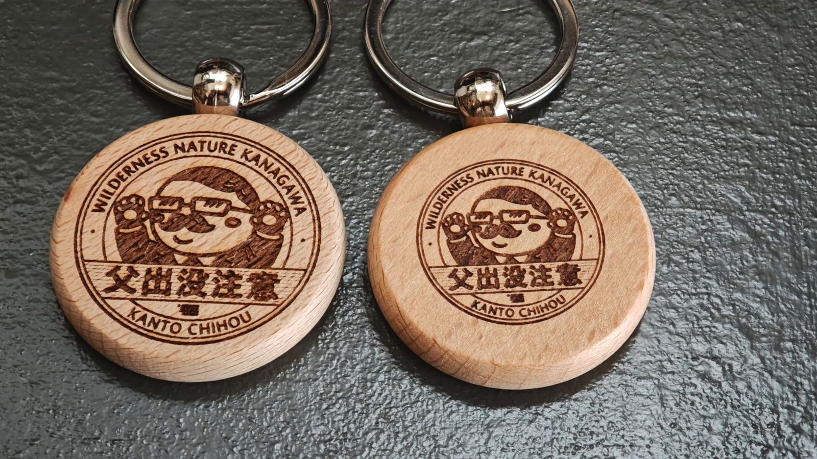 イラストの大きさと位置を変えた丸い木のキーホルダー2つ