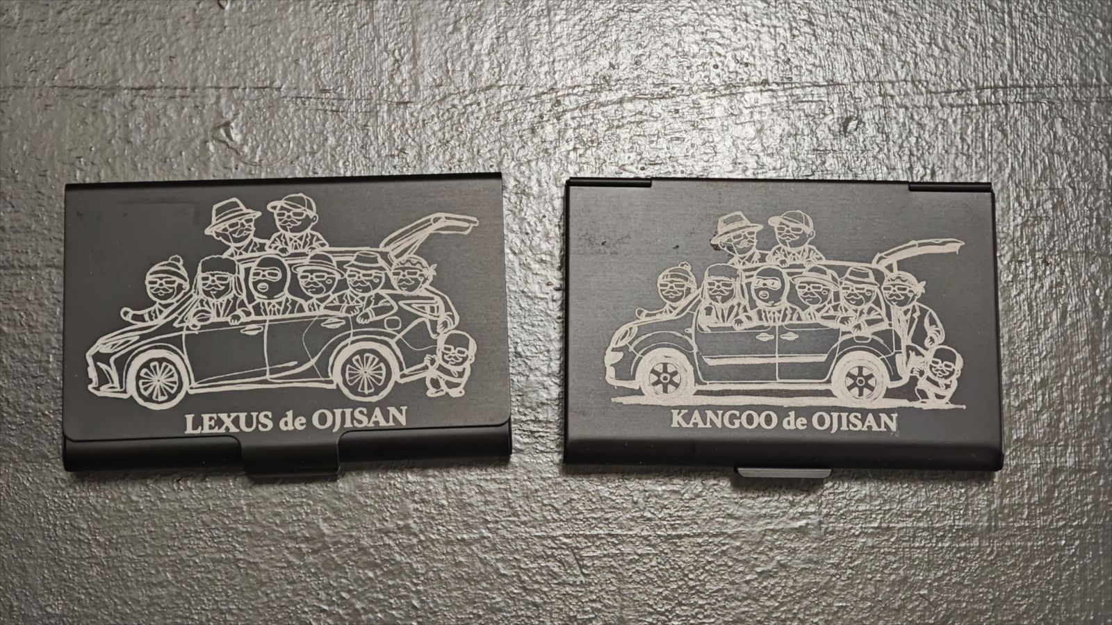車のイラストを彫刻した黒いメタルのカードケース