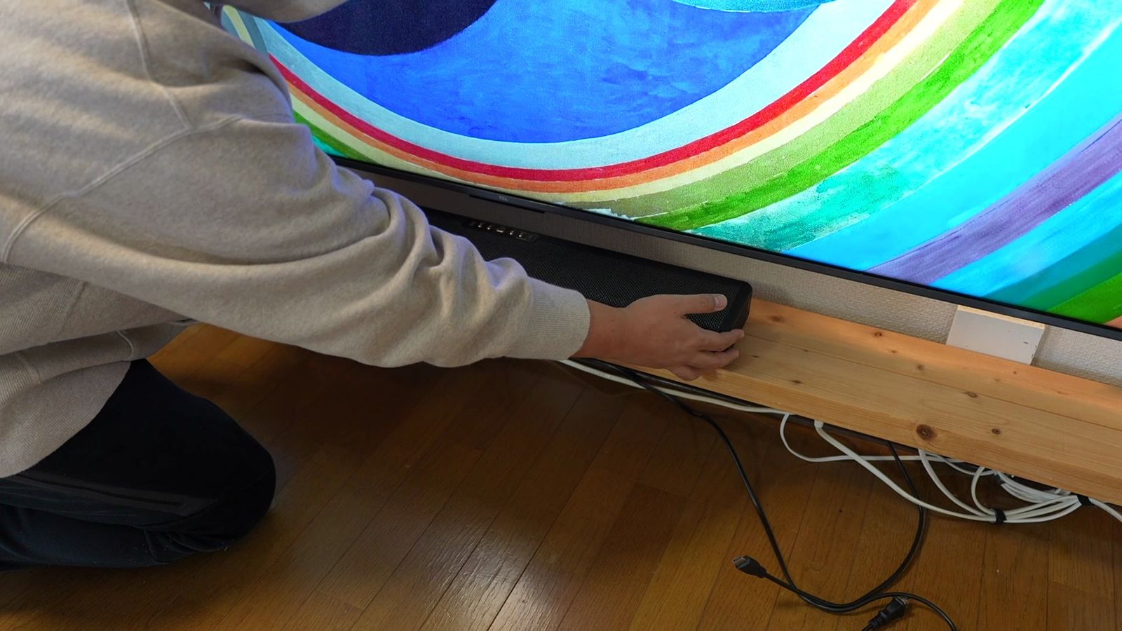 テレビの前の台にサウンドバーを置いているところ