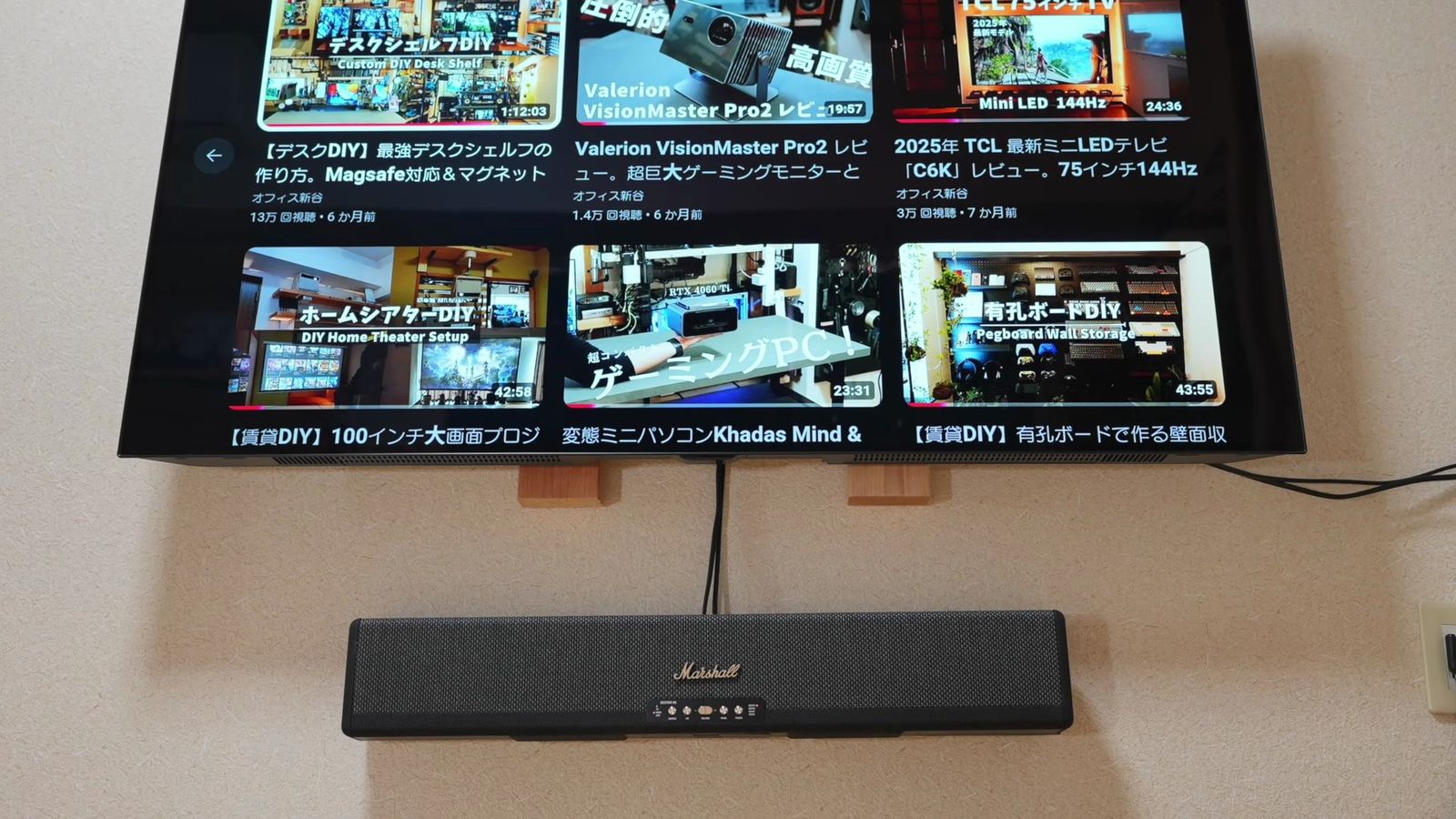 壁掛けしたテレビと、その下に壁掛けしたサウンドバー
