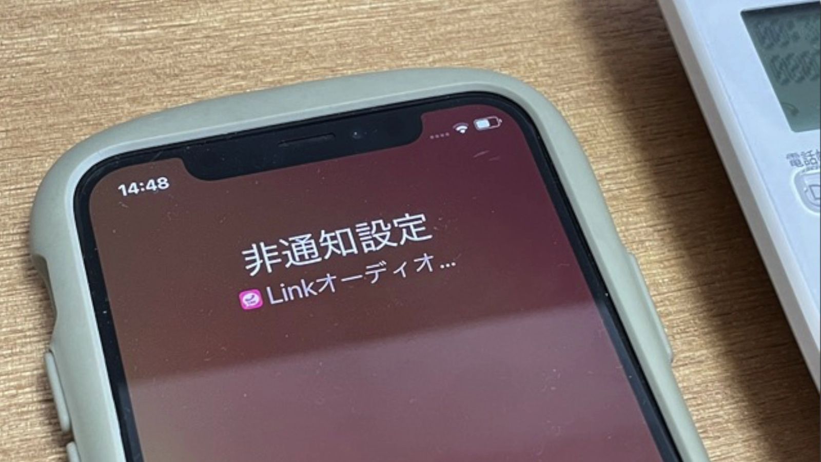 着信を受けたiPhoneの画面。「非通知設定」「Linkオーディオ…」と表示されている