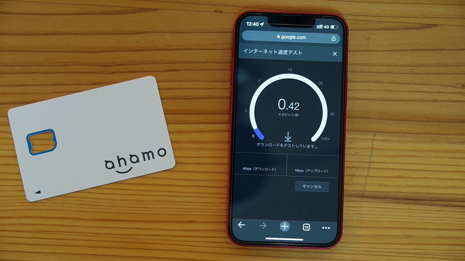 ahamoのSIMカードの横に置いたiPhoneのインターネット速度テスト。0.42Mbps