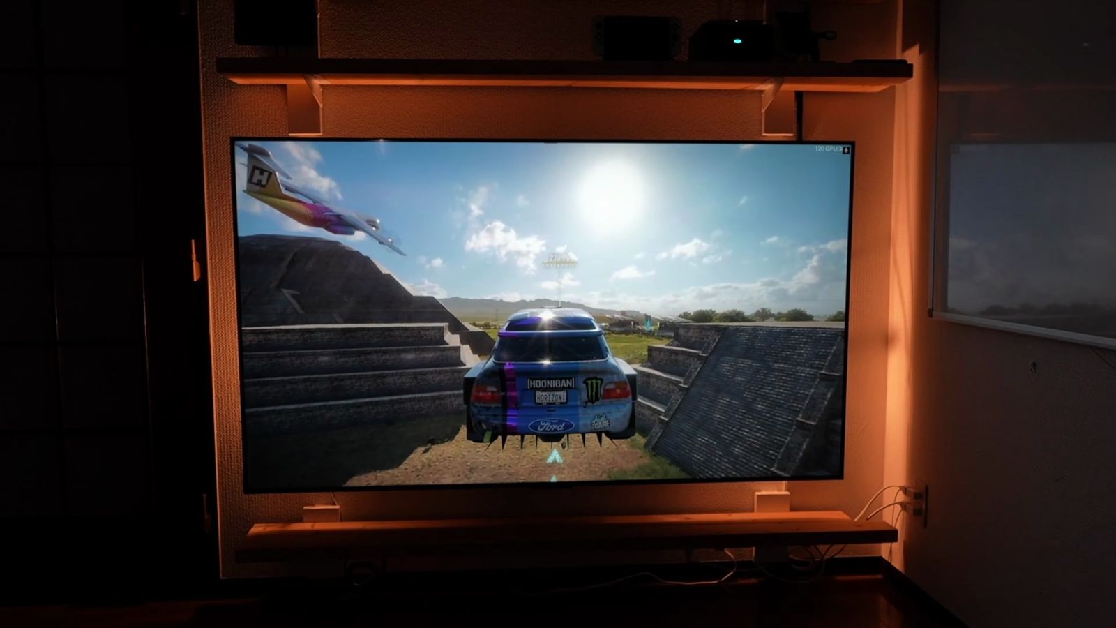 暗い部屋で壁に固定したC6Kに逆光のレースゲームを表示したところ
