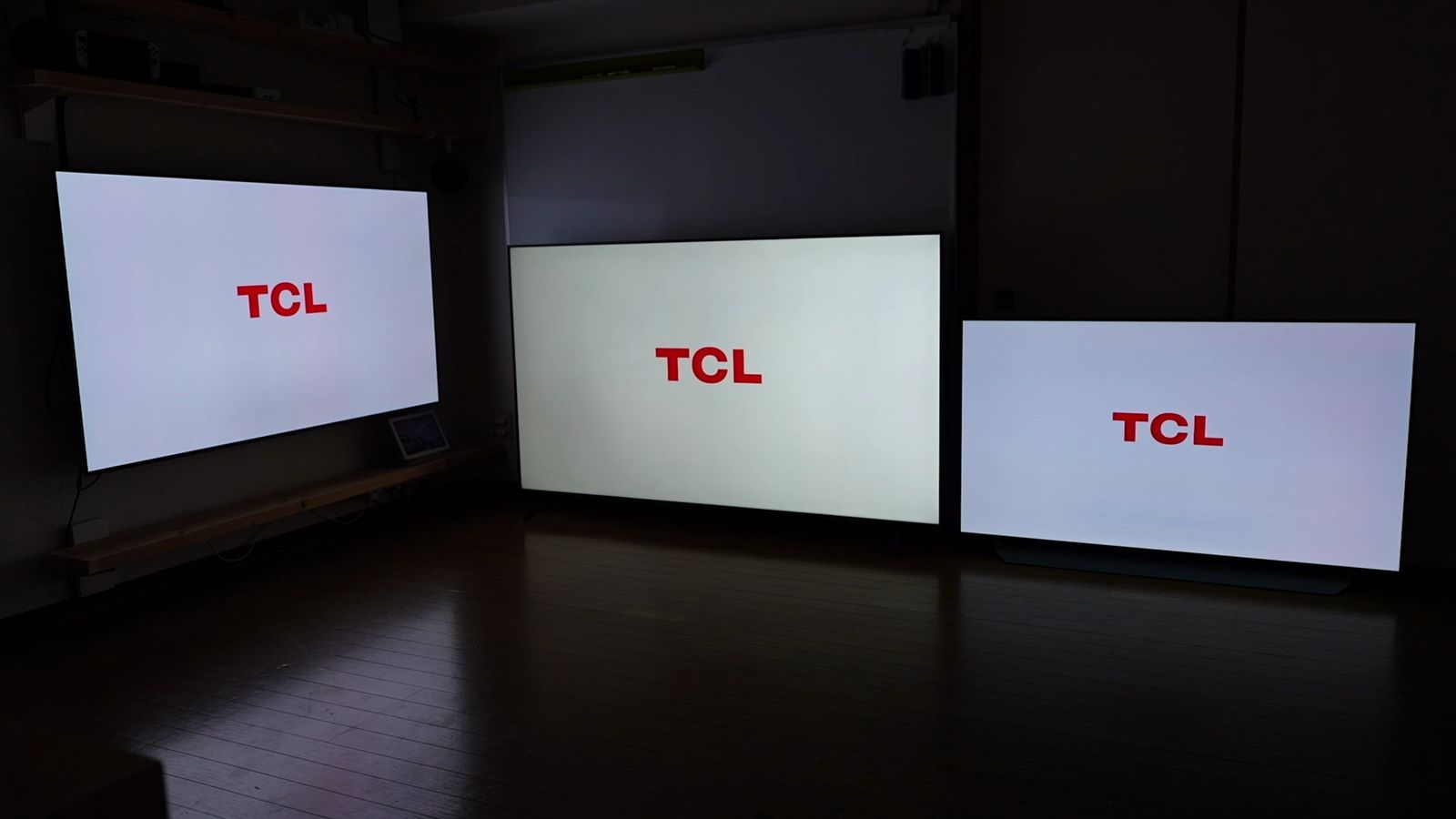 暗い部屋で3台のテレビにTCLのロゴを表示したところ