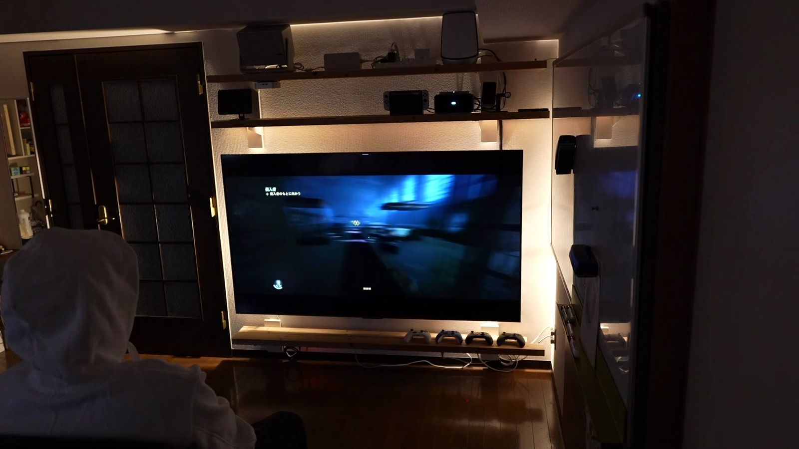 暗い部屋で少し離れた位置から壁のC6Kを見ているところ