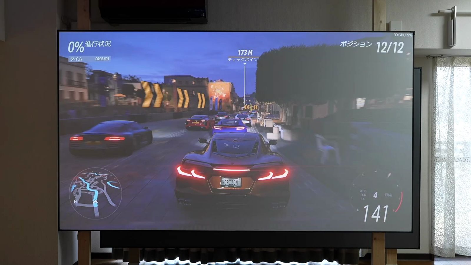 柱に掛けた固定フレームのスクリーンに、Aetherion Maxでレースゲームを投影したところ