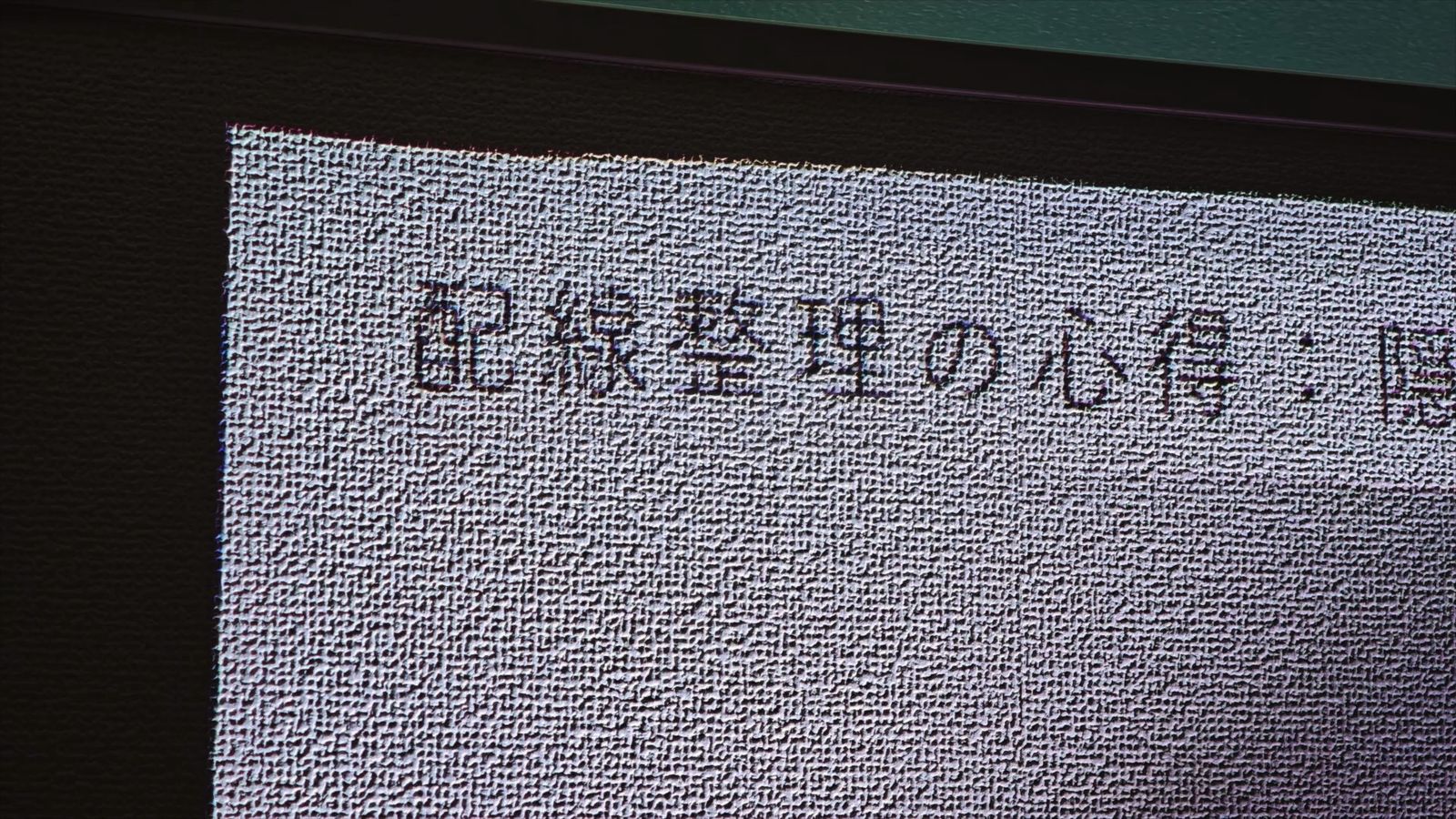 壁紙に投影した文字を近くから見たところ。壁紙の凹凸が影になって浮かんでいる