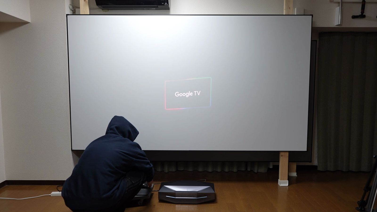 柱に掛けた白い固定フレームのスクリーンと、その前の床に置いたAetherion Max