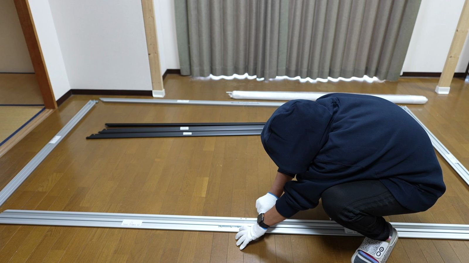 床でフレームの部材をつないで組み立てているところ