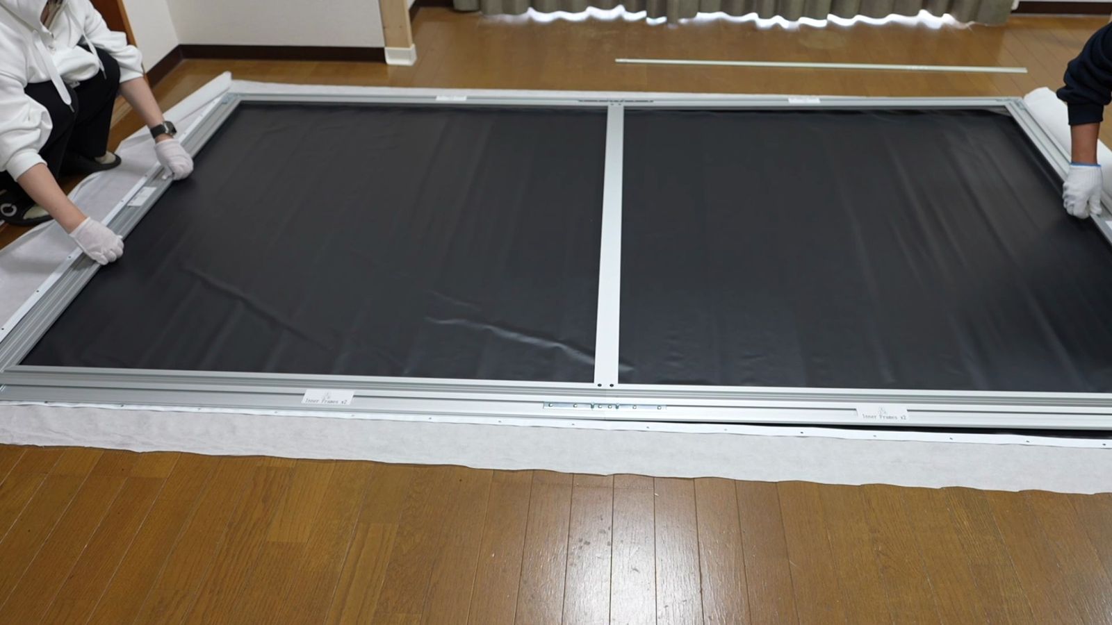 床に置いたフレームの両側で作業しているところ