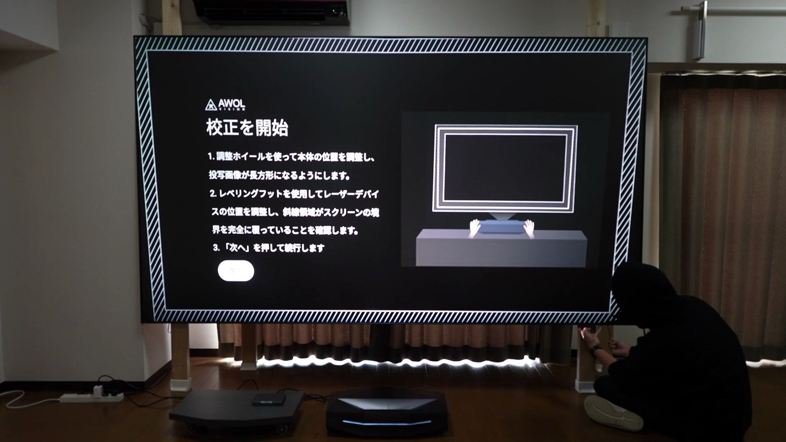 柱に掛けた白いスクリーンに投影したAetherion Maxの補正画面と、床の本体