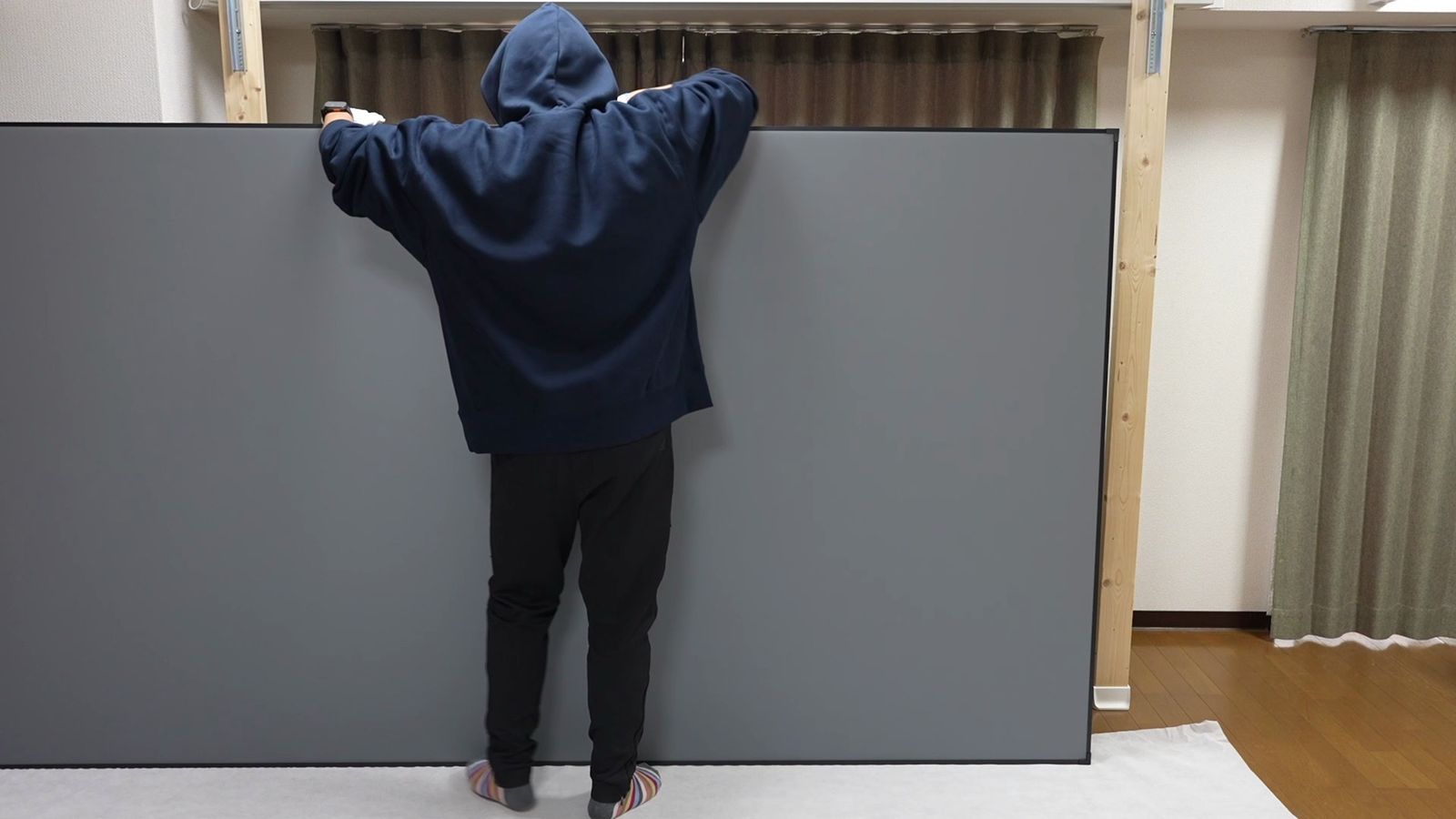 グレーのレンチキュラーALRスクリーンを両手で支えているところ