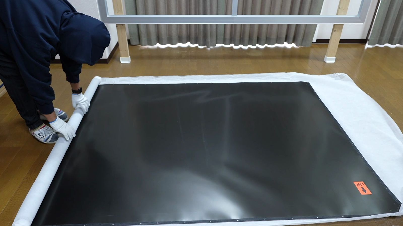 保護シートの上に広げた厚手の黒い生地